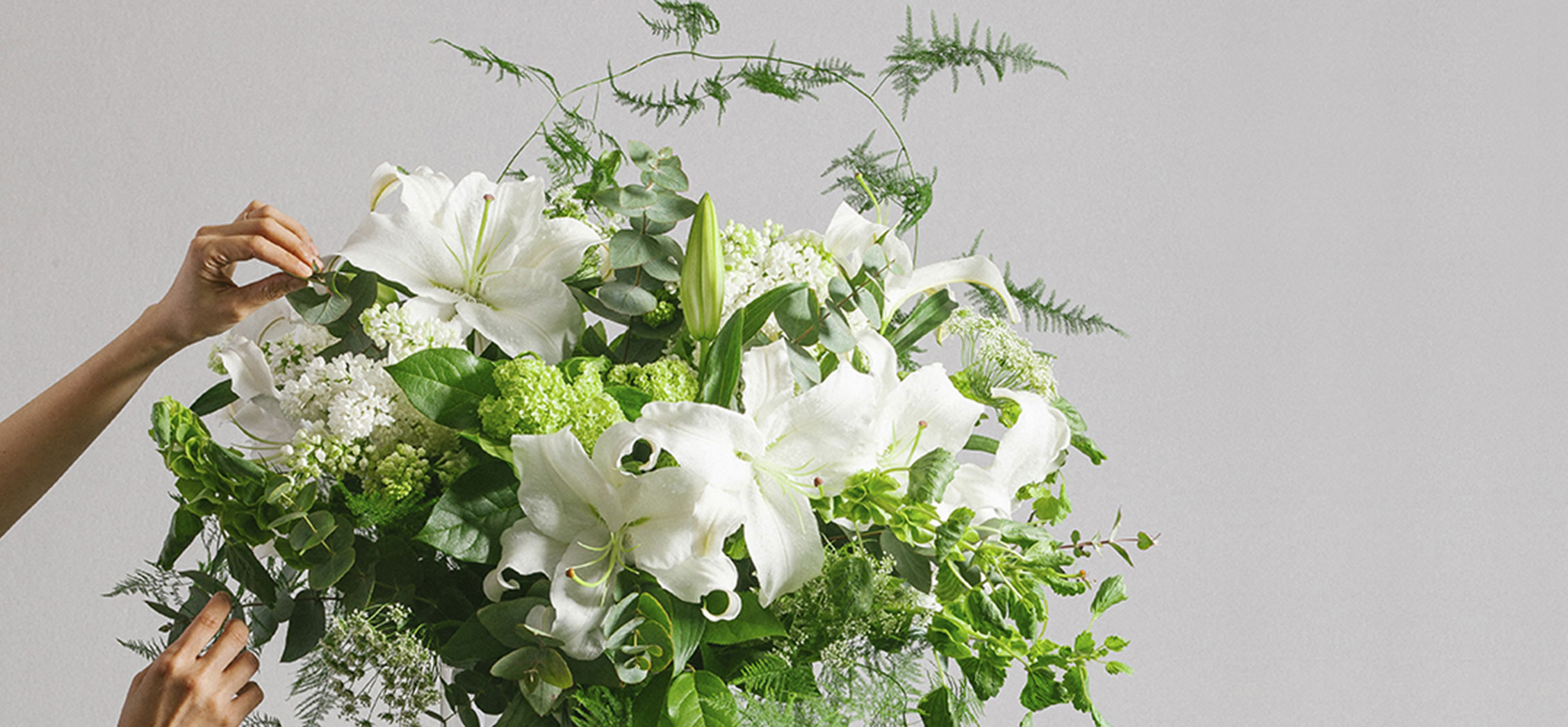 Florist arranging a premium flower bouquet of casablanca lilies. Featuring bespoke bouquet 12.