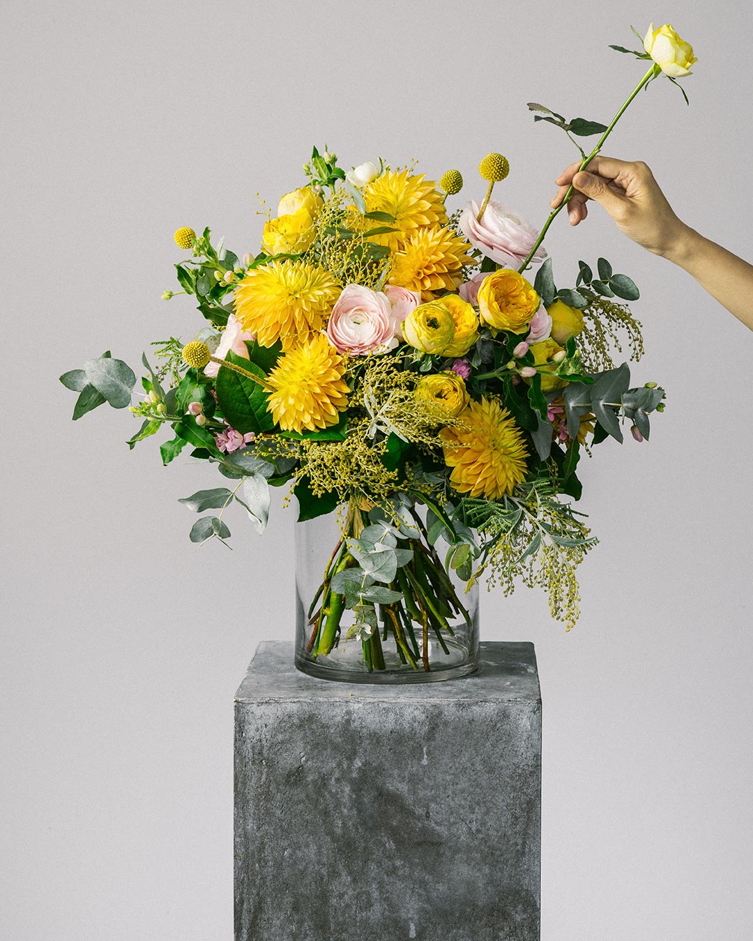 Banner image of florist arranging yellow ranunculus flower bouquet for the bespoke collection